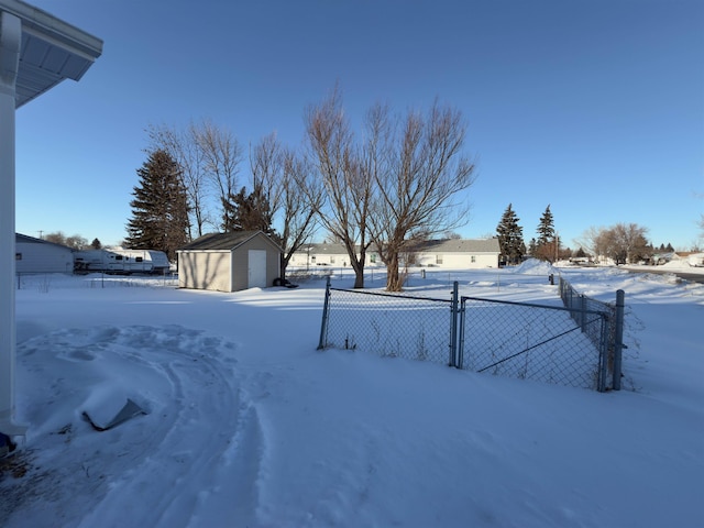 yard layered in snow with an outbuilding and a garage