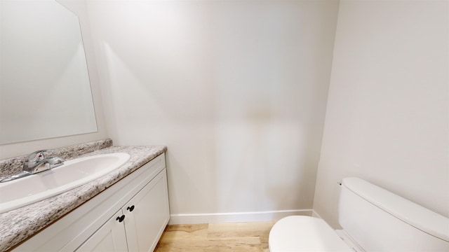 bathroom featuring hardwood / wood-style floors, vanity, and toilet