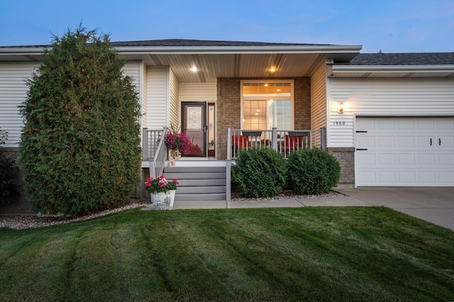 view of front facade with a lawn, a porch, and a garage