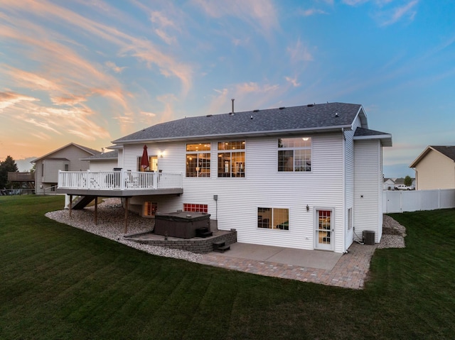 back house at dusk featuring central AC unit, a patio area, a yard, and a wooden deck