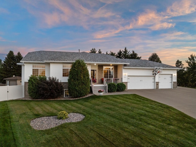 ranch-style house with covered porch, a garage, and a lawn