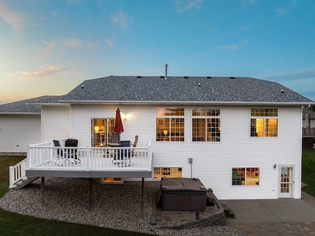 back house at dusk with a patio area and a wooden deck