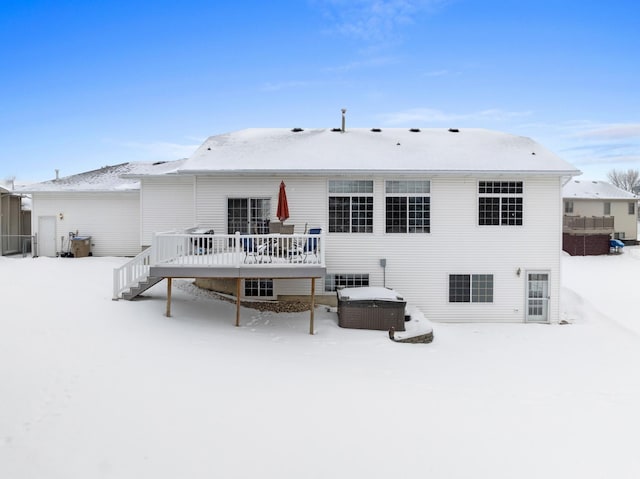 snow covered property featuring a deck and a hot tub