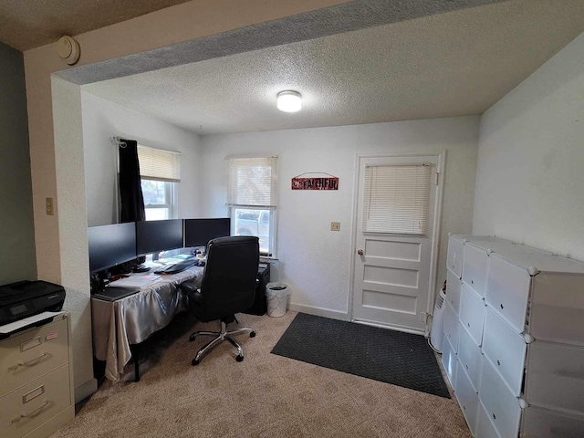 carpeted office featuring a textured ceiling