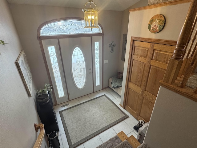 foyer featuring light tile patterned flooring and a chandelier