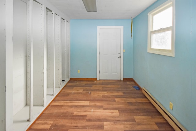 hall with a baseboard radiator and dark wood-type flooring