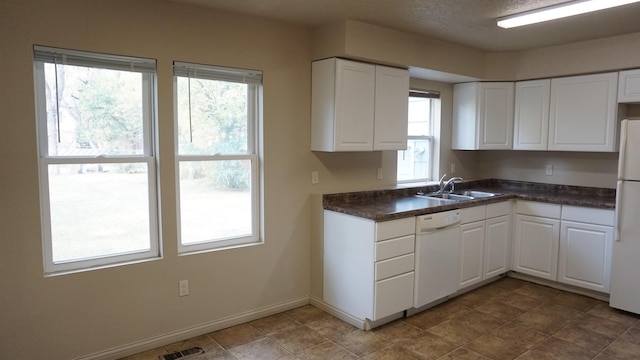 kitchen featuring white cabinets, a healthy amount of sunlight, white appliances, and sink