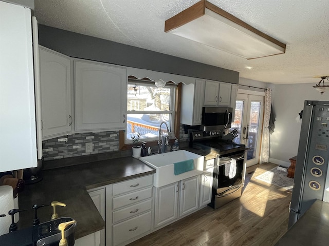 kitchen featuring tasteful backsplash, stainless steel appliances, sink, white cabinetry, and plenty of natural light