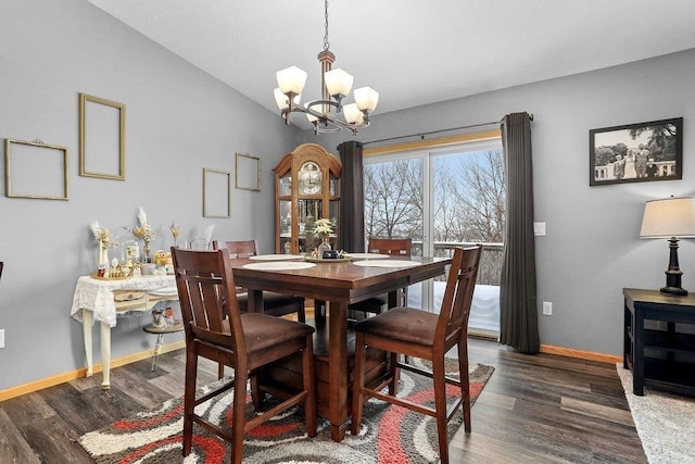 dining space with dark hardwood / wood-style flooring, vaulted ceiling, and a chandelier