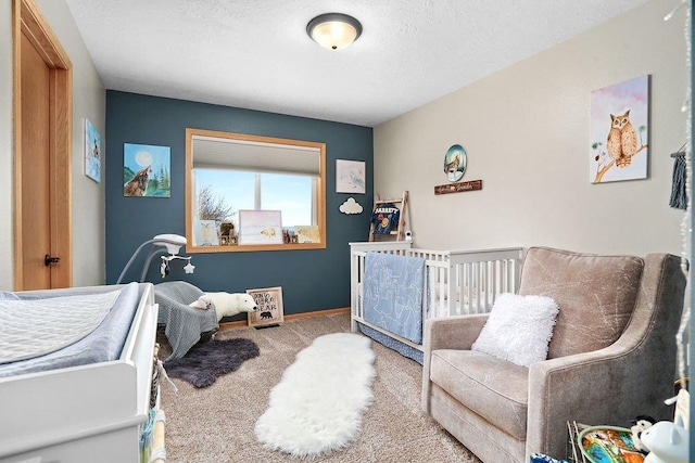 bedroom with a nursery area and carpet floors