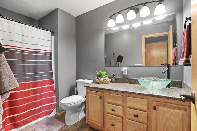 bathroom featuring toilet, vanity, and hardwood / wood-style floors