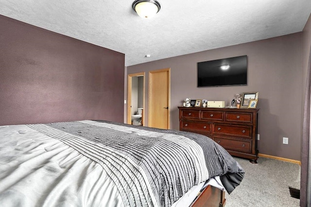 bedroom featuring light colored carpet and ensuite bath