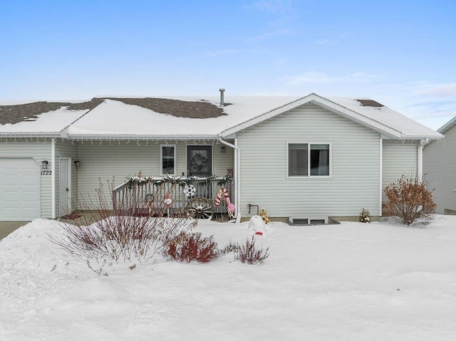 snow covered back of property featuring a deck and a garage