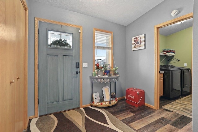 foyer with a textured ceiling, separate washer and dryer, and dark hardwood / wood-style floors