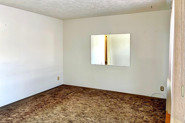 carpeted empty room featuring a textured ceiling