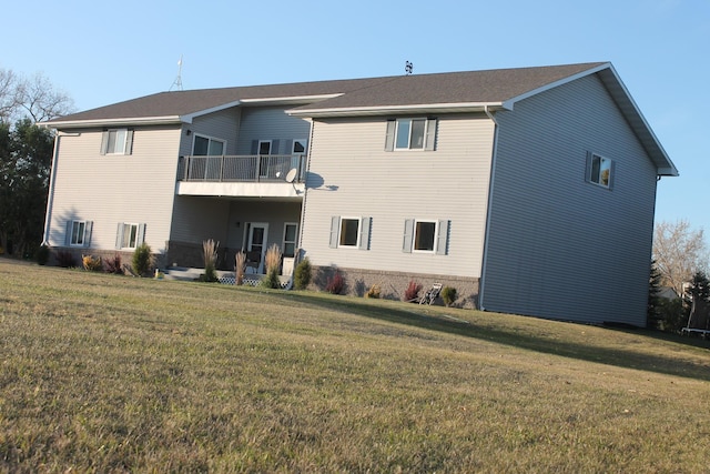 back of property featuring a yard and a balcony