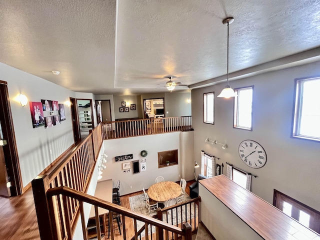 staircase featuring hardwood / wood-style floors, a textured ceiling, and ceiling fan