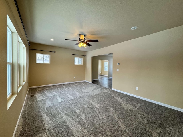 carpeted spare room with ceiling fan and a textured ceiling