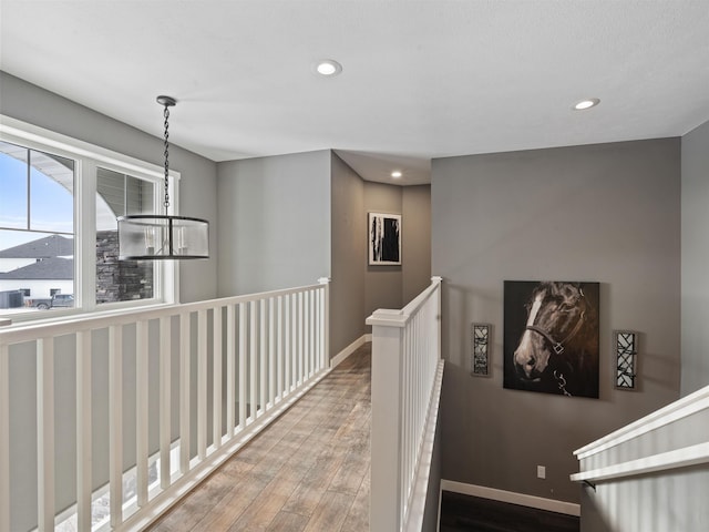 hallway with a chandelier and hardwood / wood-style floors