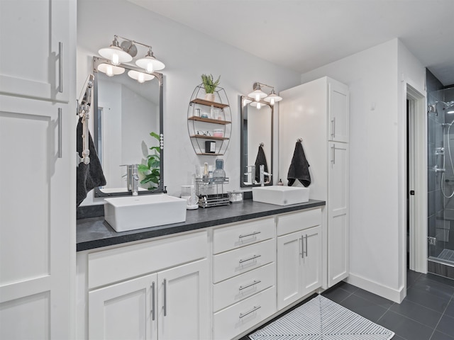 bathroom with a shower with shower door, vanity, and tile patterned flooring