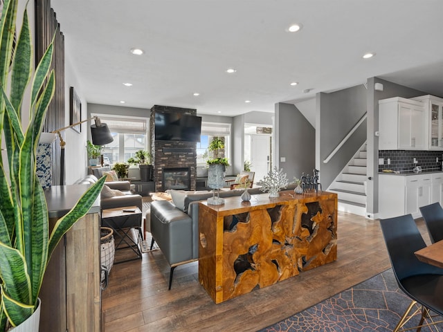 living room with a large fireplace and dark hardwood / wood-style flooring