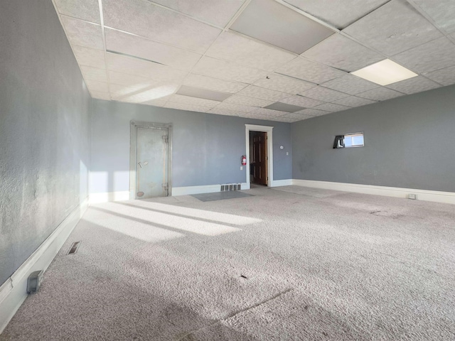 empty room with a drop ceiling and carpet flooring