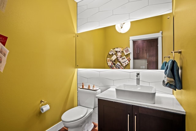 bathroom with toilet, decorative backsplash, and vanity