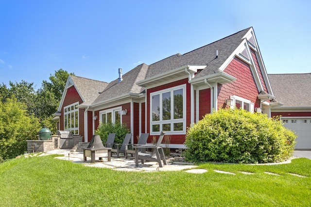 rear view of house with a patio area, an outdoor kitchen, a garage, and a yard