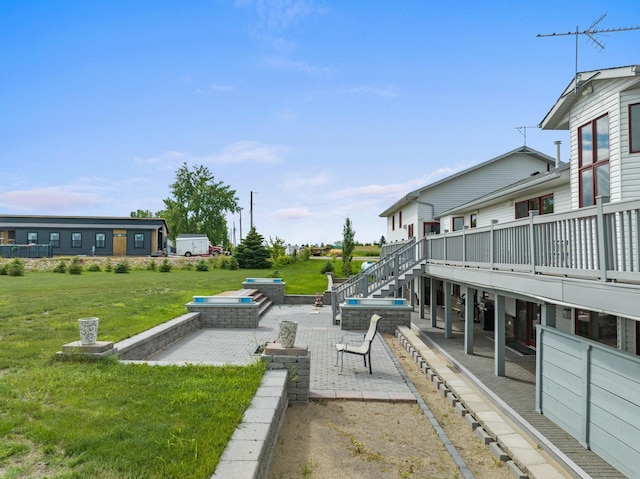 view of community with a deck, a patio area, an outdoor fire pit, and a lawn