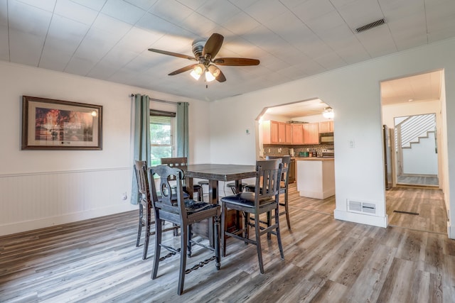 dining space with light hardwood / wood-style flooring, ceiling fan, and ornamental molding