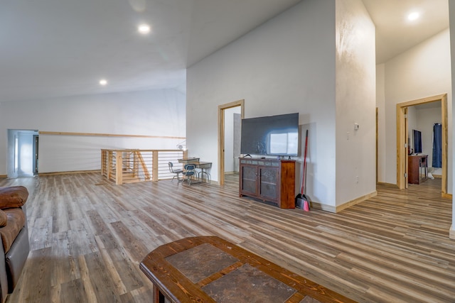 unfurnished living room featuring hardwood / wood-style flooring and high vaulted ceiling