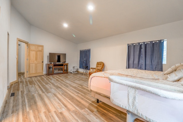 bedroom featuring high vaulted ceiling and hardwood / wood-style floors