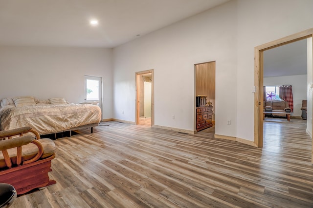 bedroom featuring wood-type flooring and a towering ceiling