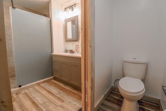 bathroom featuring vanity, toilet, a shower, and hardwood / wood-style floors