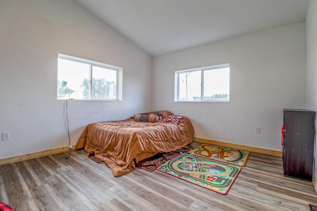 bedroom featuring light wood-type flooring and lofted ceiling