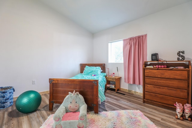 bedroom with light hardwood / wood-style flooring and lofted ceiling