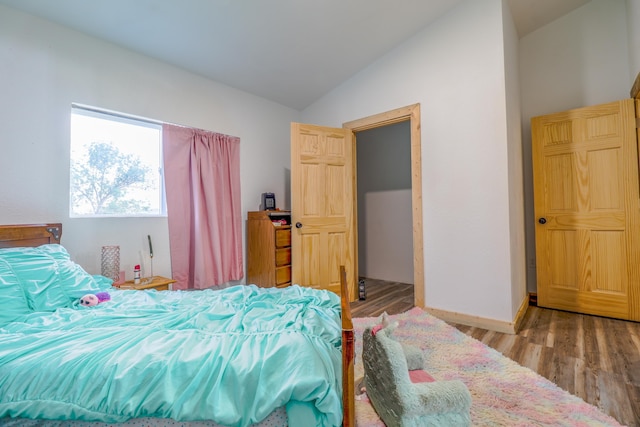 bedroom with vaulted ceiling and hardwood / wood-style floors