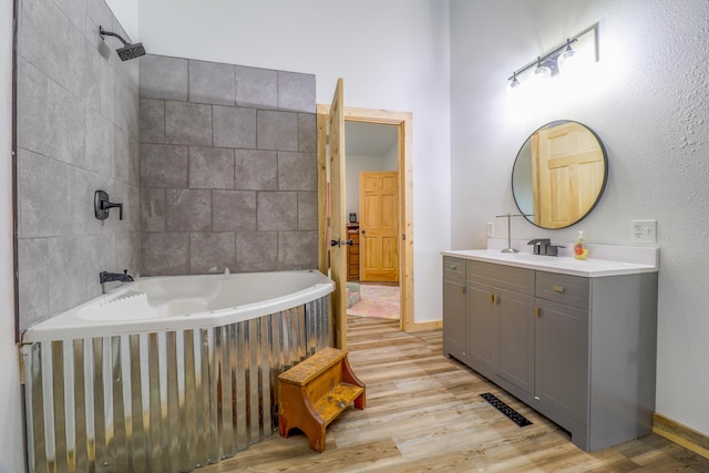 bathroom with vanity, tiled shower / bath, and wood-type flooring