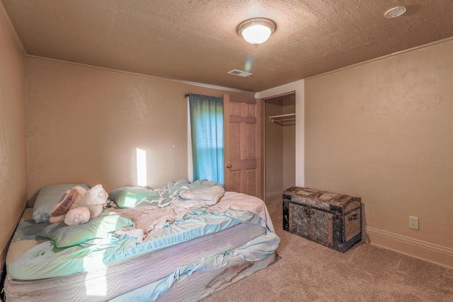 carpeted bedroom featuring a closet and a textured ceiling