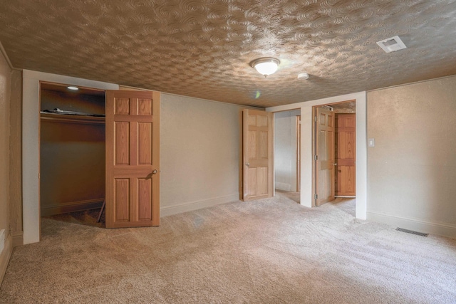 unfurnished bedroom featuring a textured ceiling, a closet, and carpet floors