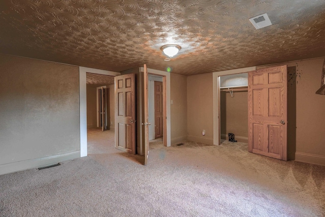 unfurnished bedroom with a textured ceiling, a closet, and carpet flooring