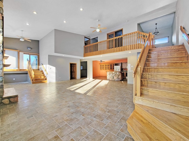 living room featuring ceiling fan and a high ceiling