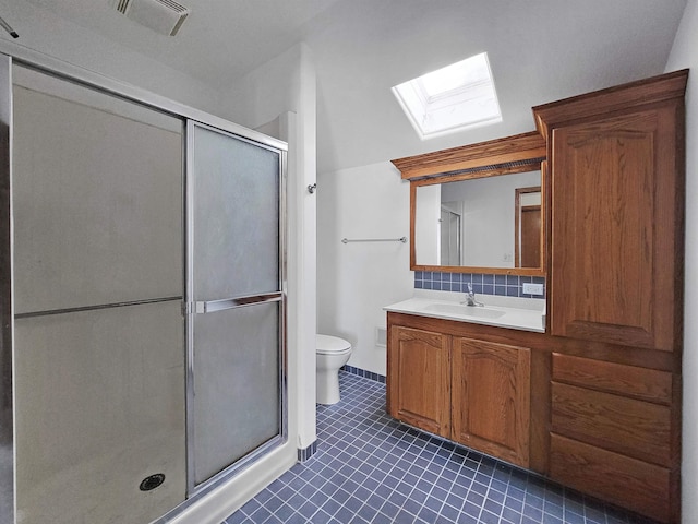 bathroom featuring a skylight, vanity, decorative backsplash, toilet, and walk in shower