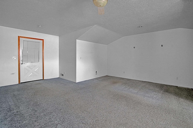 additional living space featuring carpet flooring, vaulted ceiling, and a textured ceiling