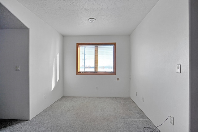 carpeted spare room featuring a textured ceiling