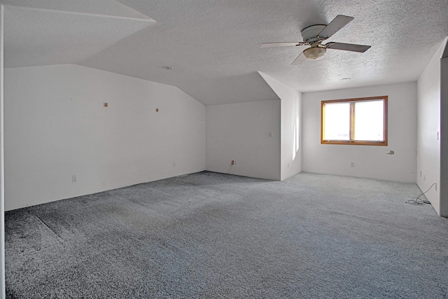 bonus room featuring vaulted ceiling, light carpet, ceiling fan, and a textured ceiling