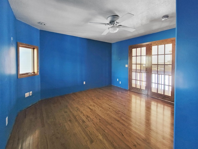 unfurnished room with french doors, ceiling fan, wood-type flooring, and a textured ceiling