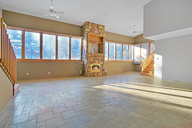 unfurnished living room with ceiling fan, a healthy amount of sunlight, and a fireplace