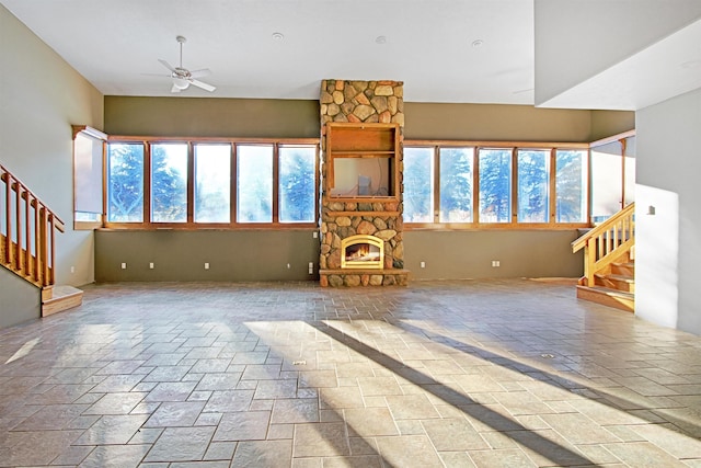 unfurnished living room with a fireplace and ceiling fan