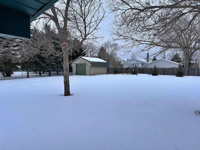 yard covered in snow with a garage and a shed